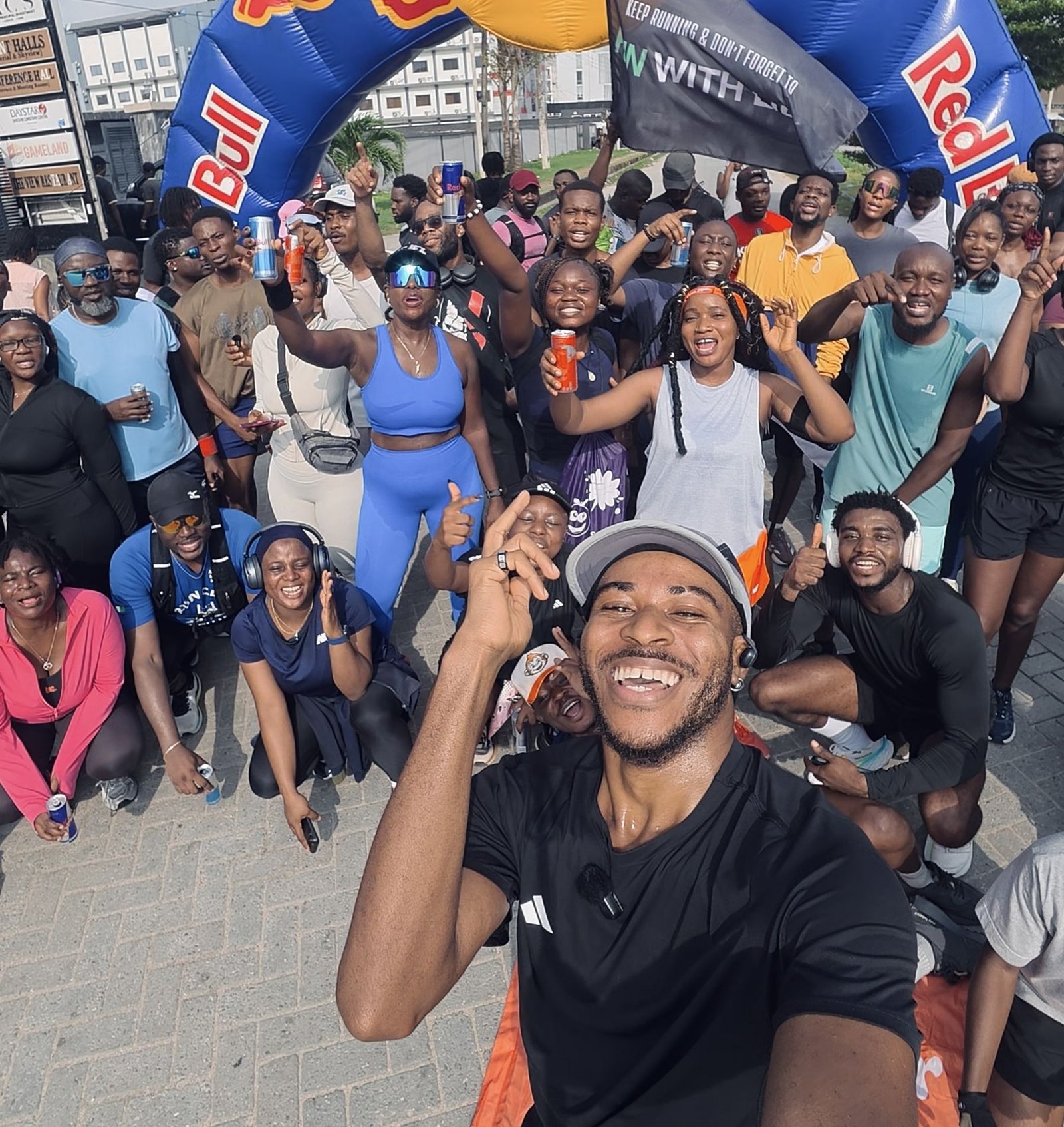 Pk holding the camera with a smiling crowd of Life Runners behind him